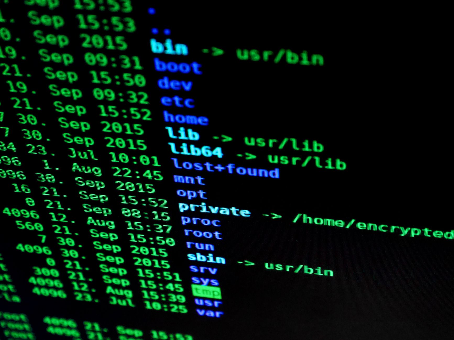 Terminal window displaying a green and blue colored directory listing with file names, dates, times, and permissions on black background