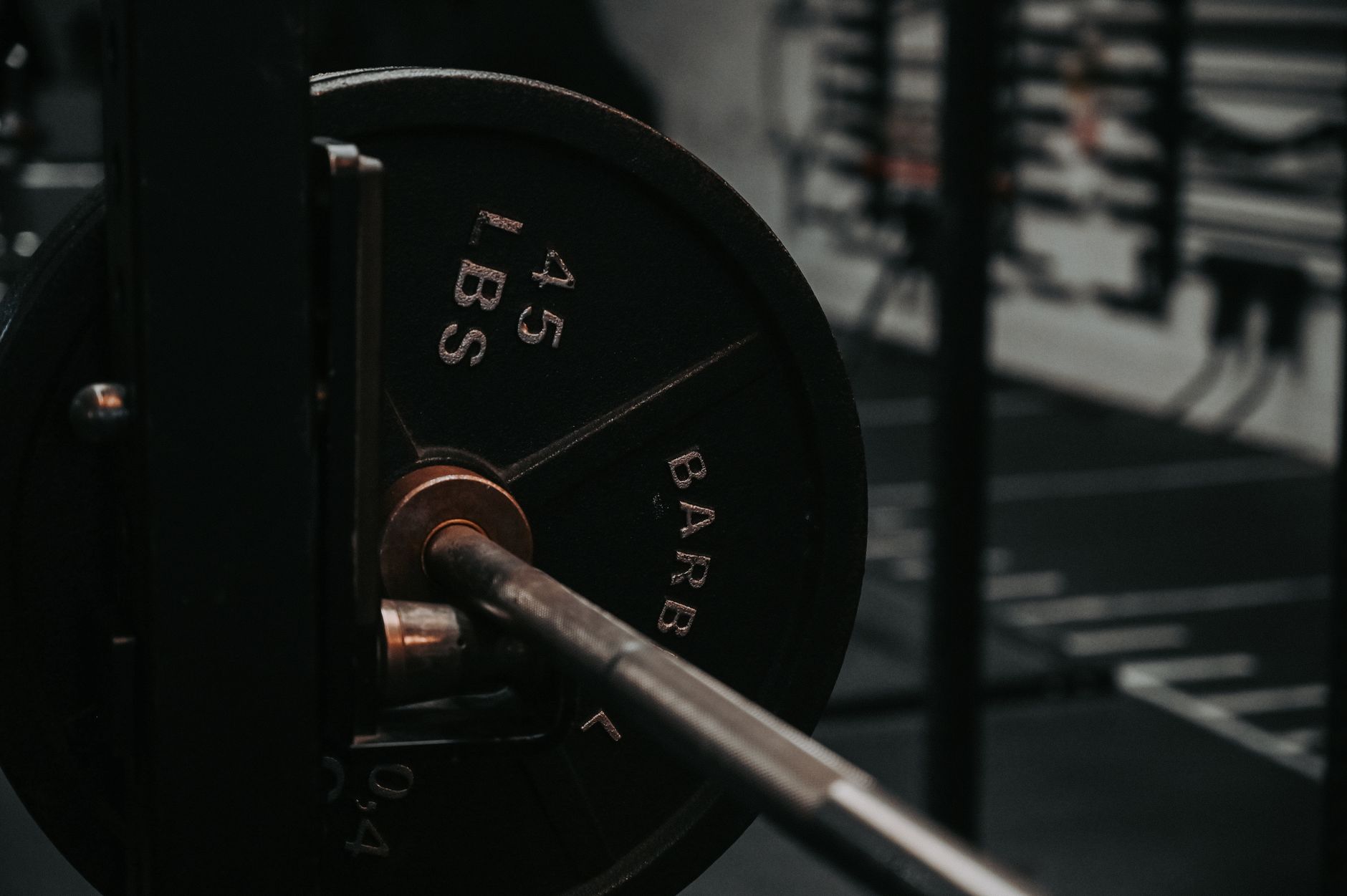 A 45 pound barbell plate loaded on a bar in a gym