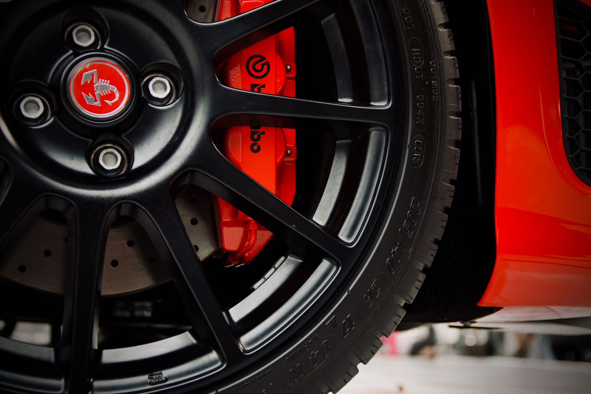Close-up of a brake caliper and rotor behind an alloy wheel